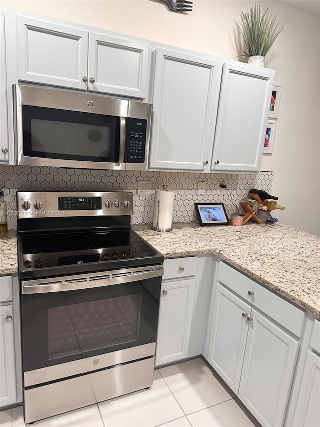 kitchen with appliances with stainless steel finishes, backsplash, and light stone counters