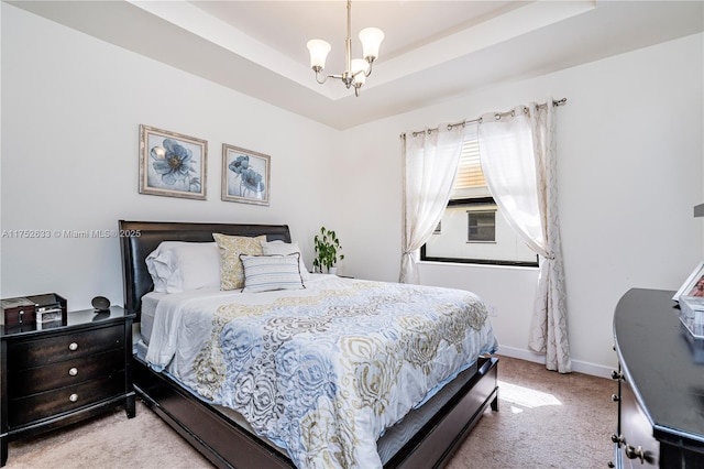 bedroom featuring a notable chandelier, carpet, a tray ceiling, and baseboards