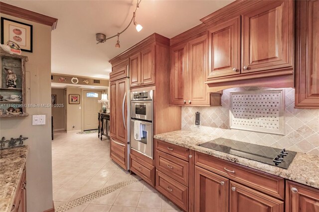 1698 S Ocean Ln Unit 171, Fort Lauderdale, FL 33316 - kitchen featuring backsplash, black electric cooktop, brown cabinets, and light tile patterned floors