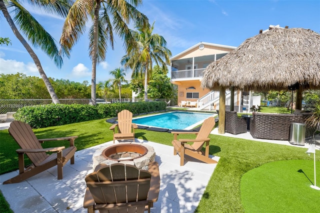 view of swimming pool featuring a patio area, fence, a fire pit, and a fenced in pool