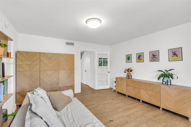 living room with visible vents and light wood-style flooring