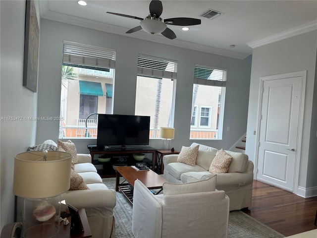 living area featuring crown molding, visible vents, plenty of natural light, and wood finished floors