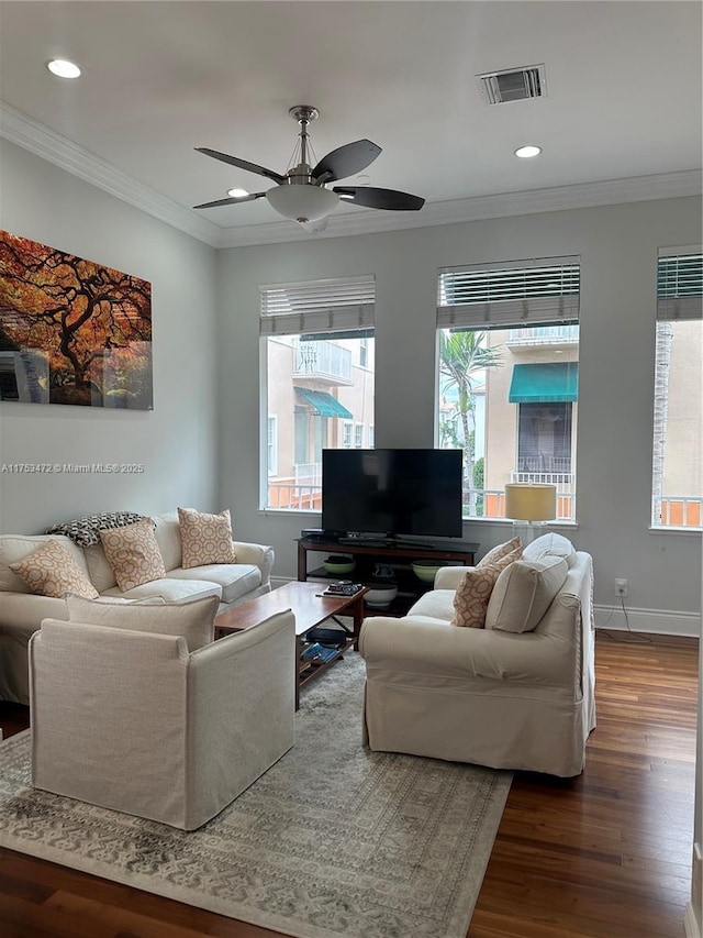 living room featuring recessed lighting, dark wood-type flooring, visible vents, baseboards, and crown molding