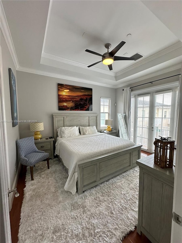 bedroom with ceiling fan, visible vents, access to exterior, ornamental molding, and a raised ceiling