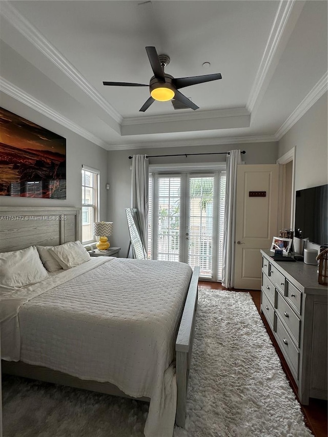 bedroom featuring access to outside, a raised ceiling, ceiling fan, and french doors