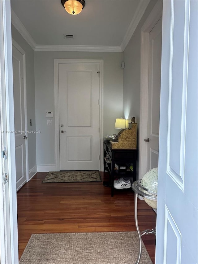 interior space with visible vents, ornamental molding, and wood finished floors