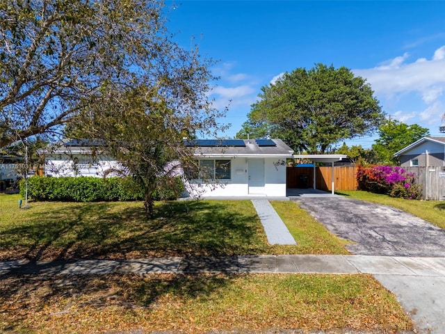 single story home with a front lawn, fence, aphalt driveway, and an attached carport