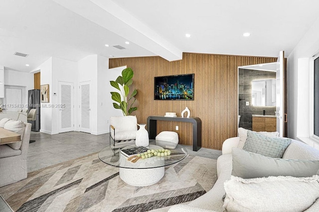 living area featuring lofted ceiling with beams, wood walls, visible vents, and recessed lighting