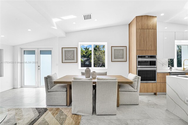 dining space with lofted ceiling, plenty of natural light, visible vents, and french doors