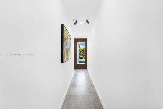 hall with concrete flooring, recessed lighting, visible vents, and baseboards