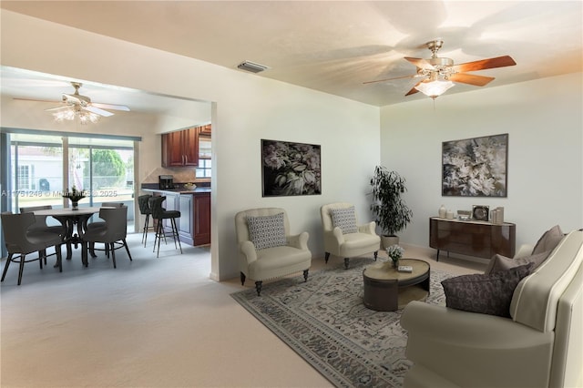 living area with visible vents and a ceiling fan