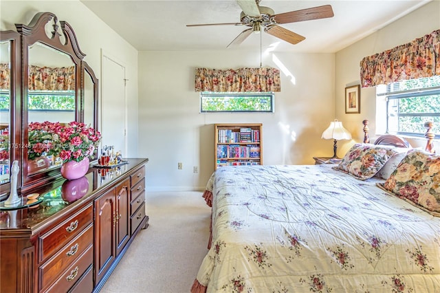 bedroom with light carpet, baseboards, and a ceiling fan