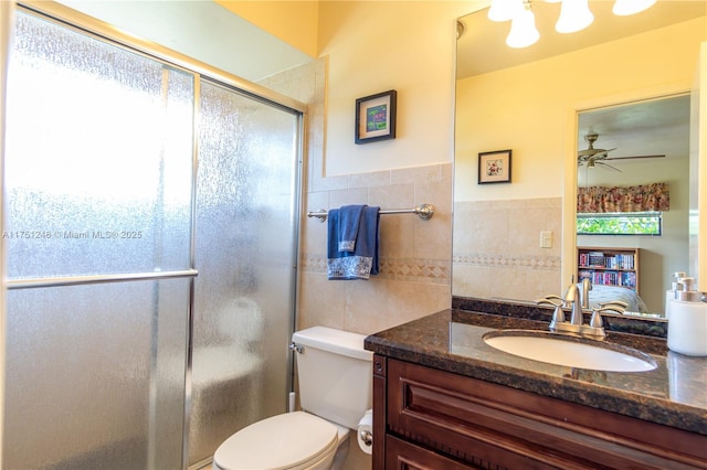 bathroom featuring a stall shower, toilet, tile walls, and vanity