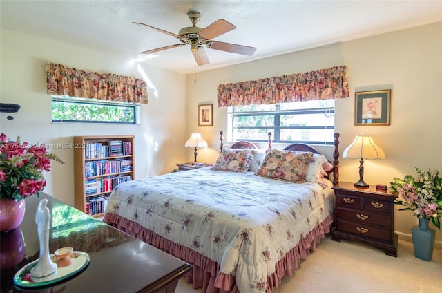 bedroom featuring light carpet, ceiling fan, and multiple windows