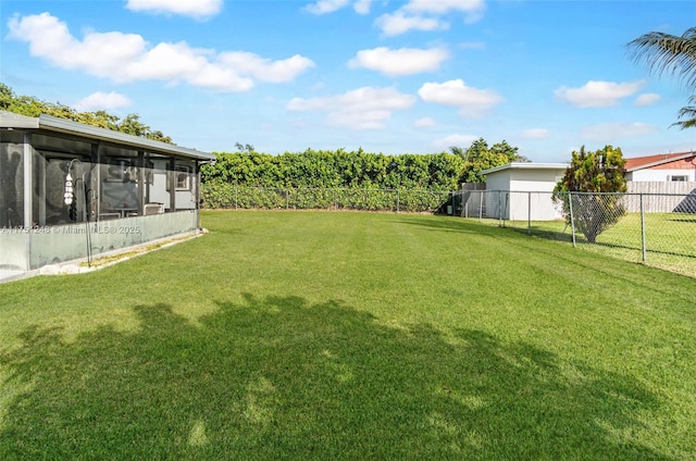 view of yard featuring a sunroom and a fenced backyard