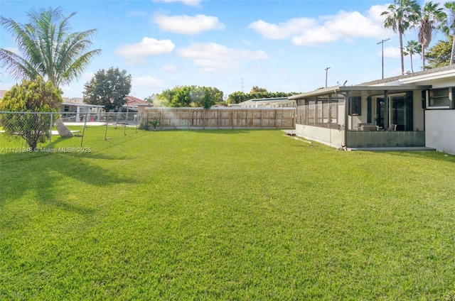 view of yard with a sunroom and a fenced backyard