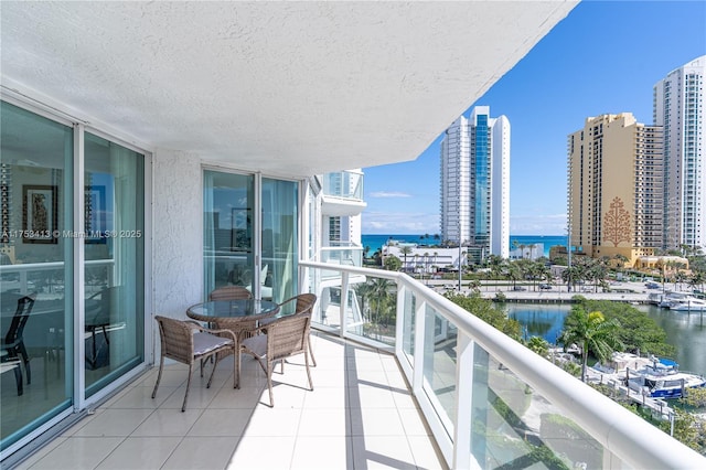 balcony with a water view and a view of city