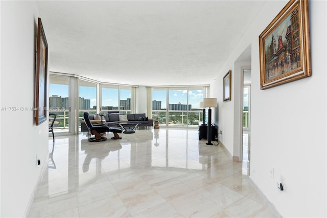 living area with expansive windows, a city view, a textured ceiling, and baseboards