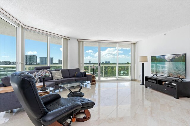 living room featuring floor to ceiling windows, plenty of natural light, a city view, and a textured ceiling