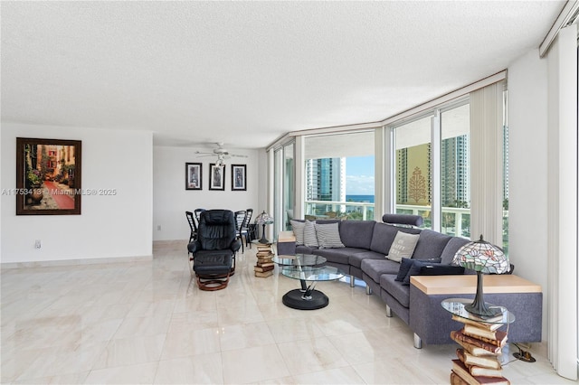 living room featuring ceiling fan and a textured ceiling