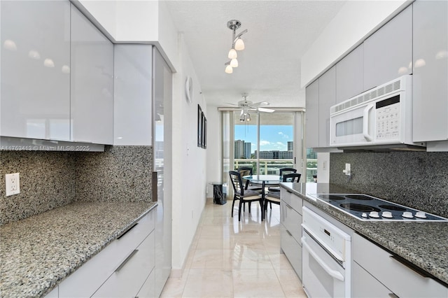 kitchen featuring a ceiling fan, white appliances, a textured ceiling, and decorative backsplash