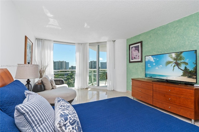 bedroom with access to outside, floor to ceiling windows, and a textured ceiling