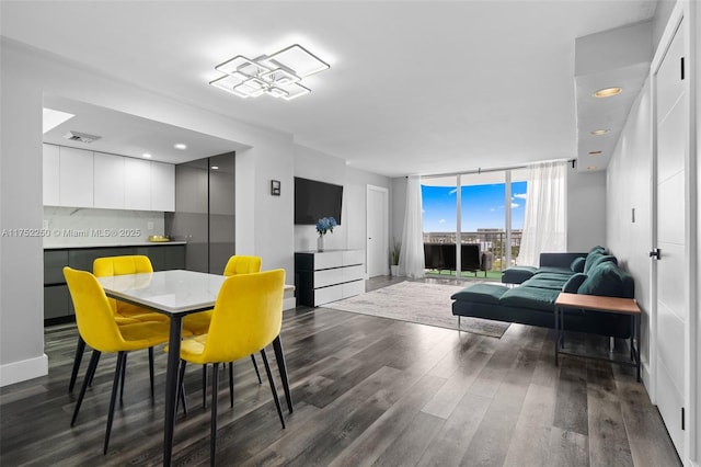 dining area featuring floor to ceiling windows, visible vents, baseboards, and wood finished floors