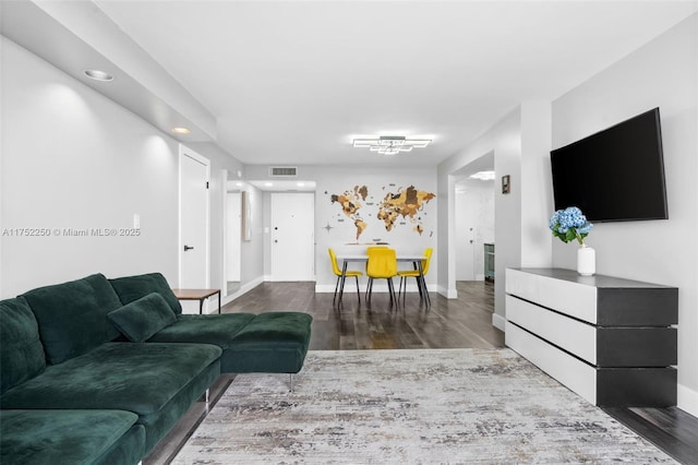 living area featuring wood finished floors, visible vents, and baseboards