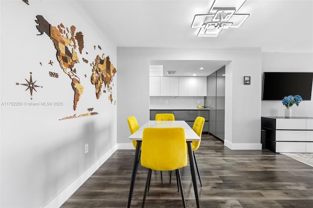 dining space featuring dark wood-style flooring and baseboards