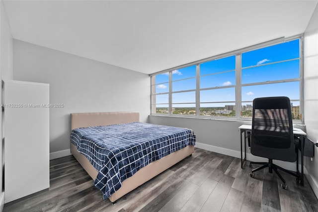 bedroom with baseboards and wood finished floors