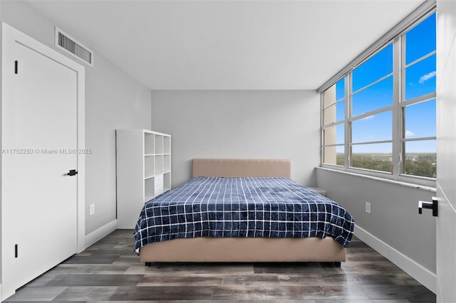 bedroom featuring baseboards, visible vents, and wood finished floors