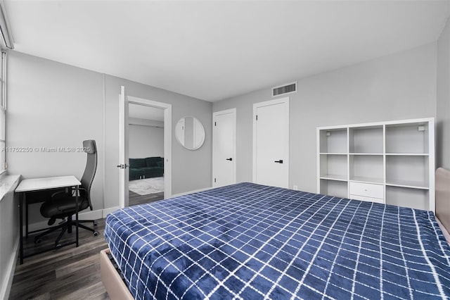 bedroom featuring baseboards, visible vents, and wood finished floors