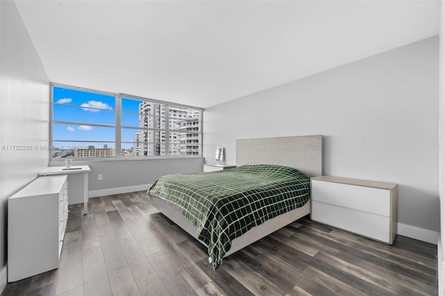 bedroom with wood finished floors and baseboards