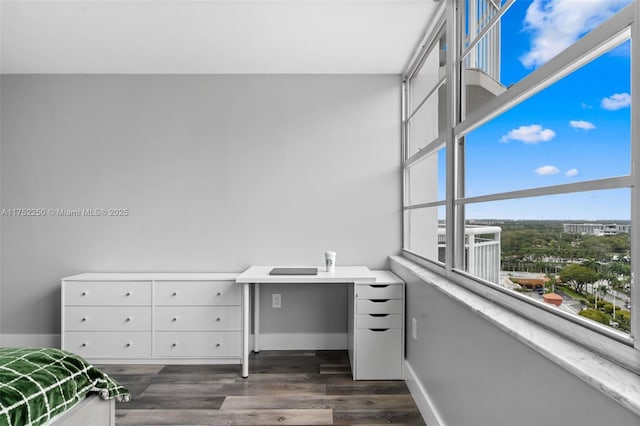 office space with baseboards and dark wood finished floors