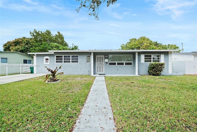 ranch-style house featuring a front yard, fence, and stucco siding