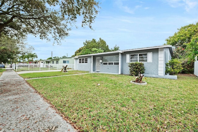 ranch-style home with stucco siding, fence, and a front yard