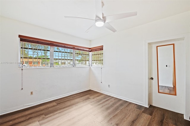 unfurnished room featuring a ceiling fan, baseboards, and wood finished floors