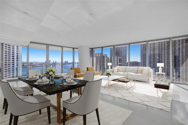 dining area featuring a view of city, concrete floors, expansive windows, and a water view