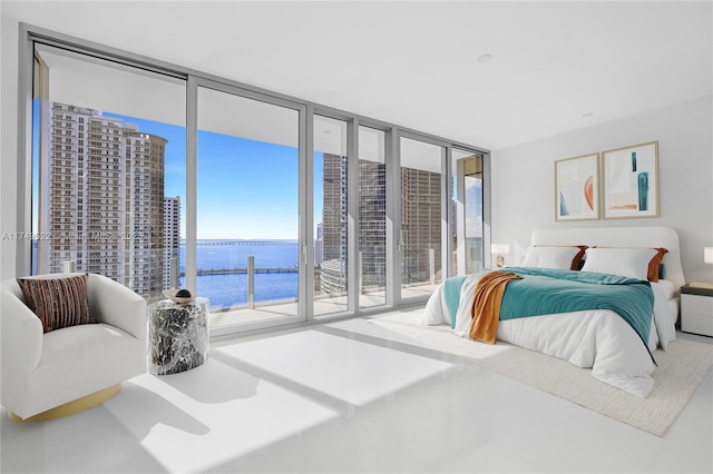 bedroom with access to exterior, a water view, and floor to ceiling windows