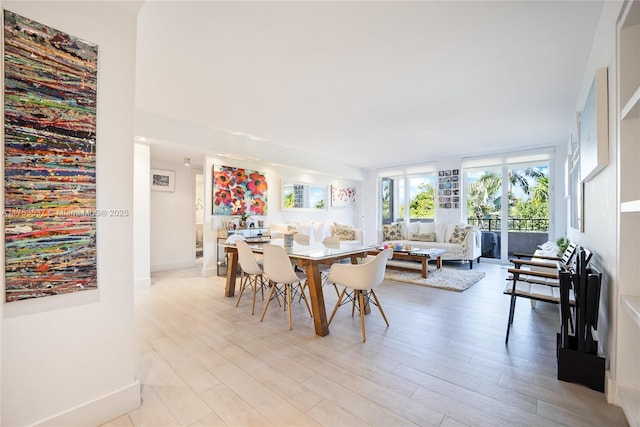 dining area featuring light wood-style floors and baseboards