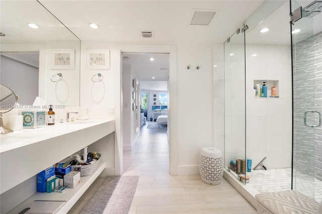 bathroom with double vanity, a stall shower, visible vents, ensuite bath, and a sink