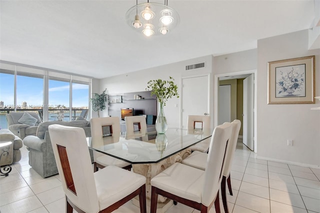 dining space with light tile patterned floors, expansive windows, visible vents, and baseboards