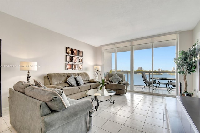 living room featuring light tile patterned floors, a wall of windows, and a water view