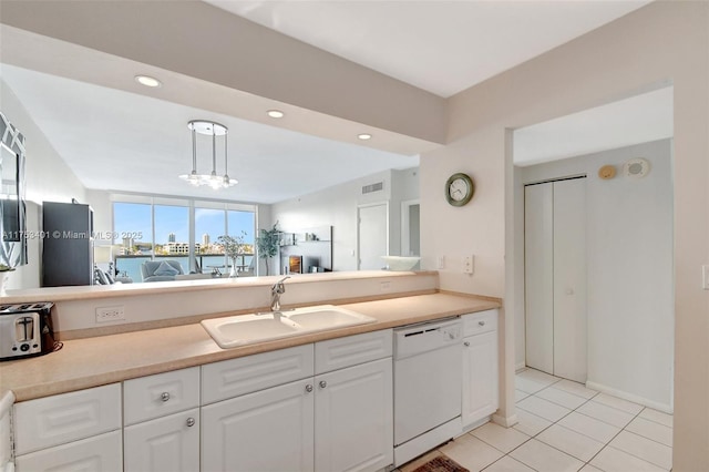 kitchen with white dishwasher, light countertops, white cabinetry, pendant lighting, and a sink