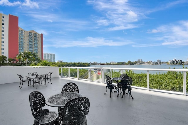 view of patio featuring a water view, a balcony, and a city view