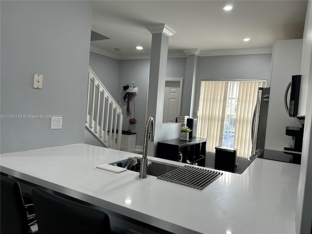 kitchen featuring recessed lighting, refrigerator, crown molding, and ornate columns