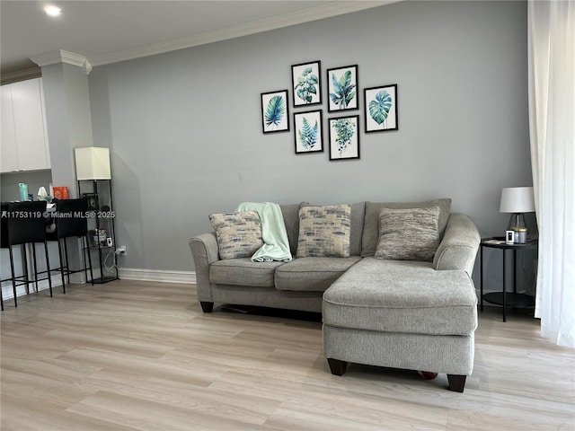 living room with light wood-style flooring, baseboards, and crown molding