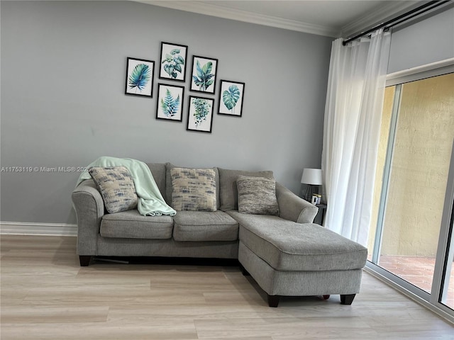 living room with light wood-type flooring, plenty of natural light, baseboards, and crown molding