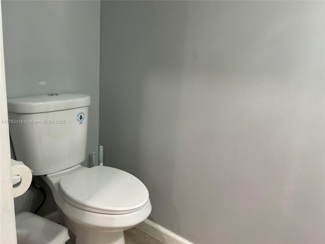 bathroom with toilet and baseboards