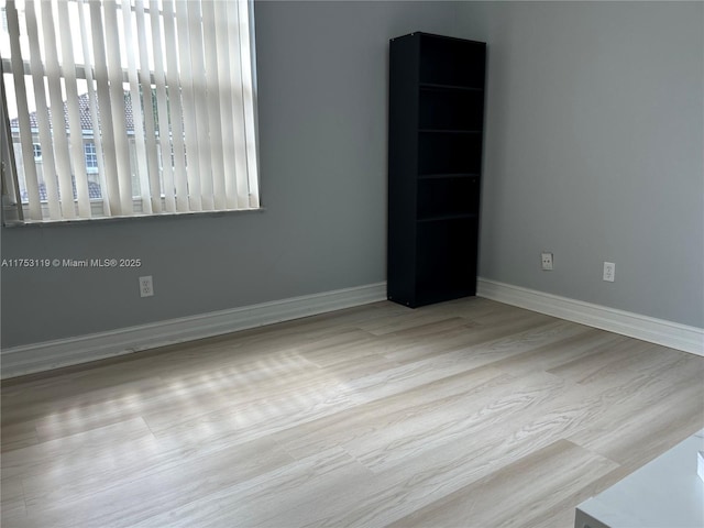 unfurnished room featuring baseboards and wood finished floors